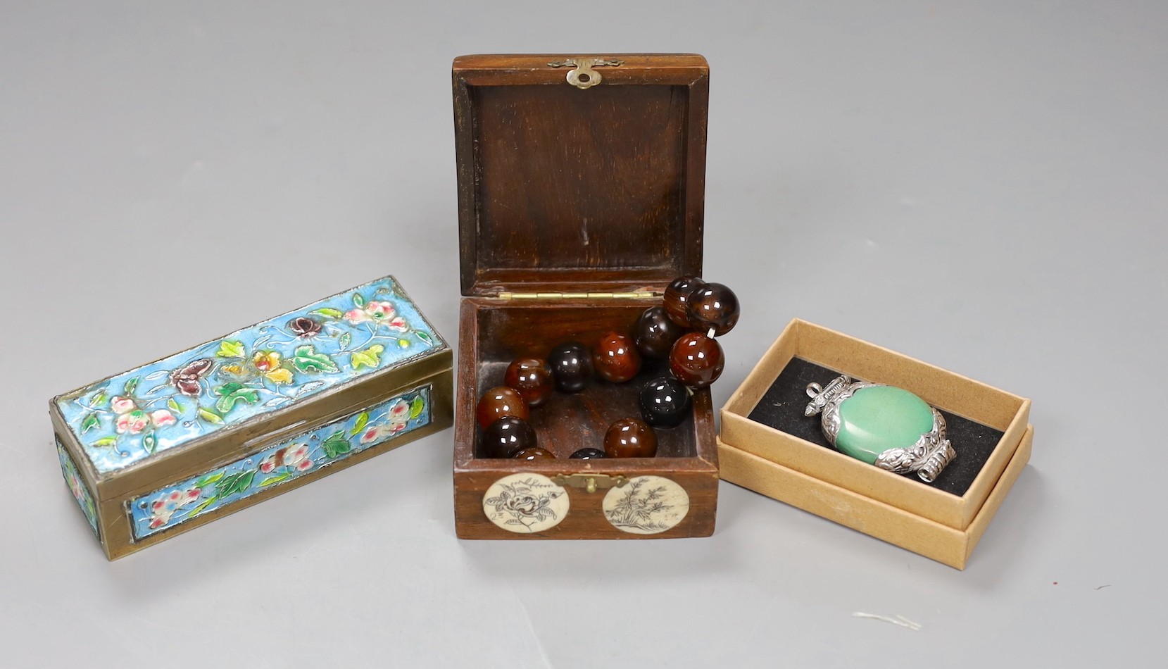 A Chinese enamel on brass stamp box, a Tibetan amulet, an agate bead rosary and a bone inlaid box and cover, enamel box, 11cms x 3.5cms high (4)